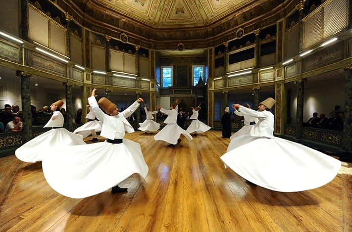 đia-điểm-du-lịch-thổ-nhĩ-kỳ-Whirling dervishes perform at the Galata Whirling Dervish Hall, founded in 1491 by the Ottomans, in Istanbul, Turkey, on the second day of Muslims' holy month of Ramadan, late Tuesday, Aug. 2, 2011. Sufi whirling performance of the Mevlevi order is part of a formal ceremony known as the Sama. The order was founded by the Persian-Turkish poet Mowlana Jalaluddin Rumi, one of the greatest mystic poets of Sufism in Islam, born in 1207 in Balkh, then in the Persian province of Khorasan and now in Afghanistan, and died in 1273 in Konya, Turkey. His Sufism being a mysticism within Islam where devotees sought a mystical union with God. Rumi advocates unlimited tolerance, positive reasoning, goodness, charity and awareness through love for all regardless their faiths. (AP Photo)